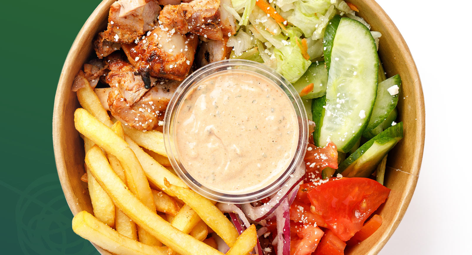 Food bowl with diced chicken, fries, veggies, and dipping sauce