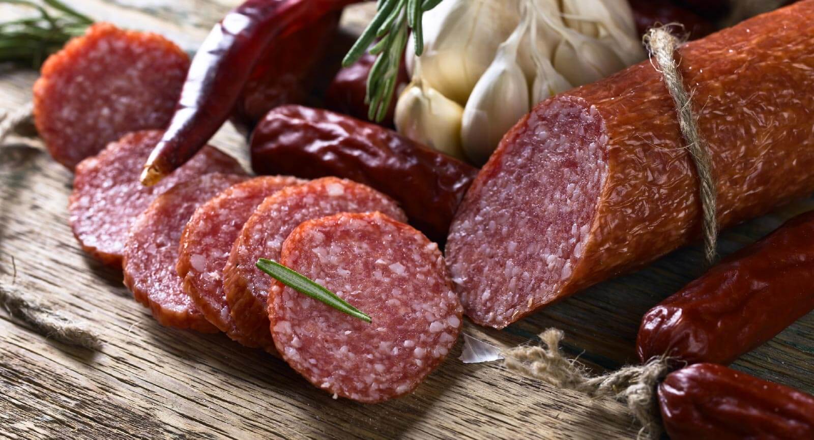 sliced pepperoni or sausage on a cutting board