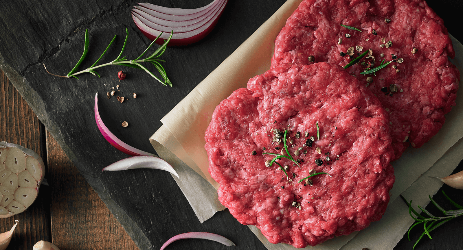 Raw hamburger patties and rosemary