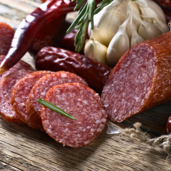 sausage pepperoni  slide on a cutting board