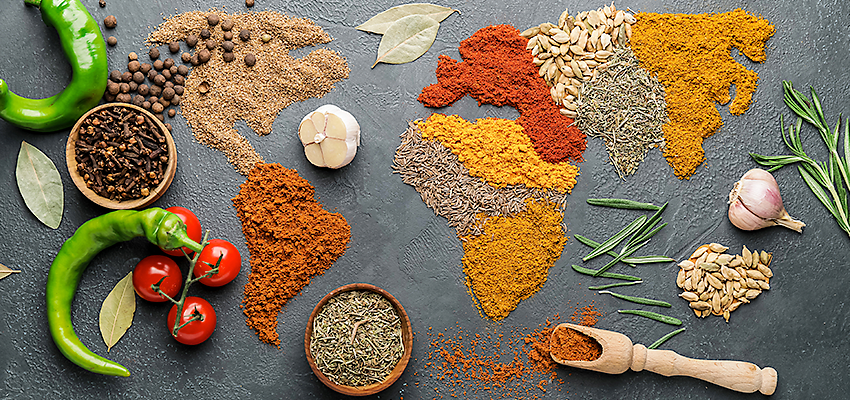 A variety of spices, ingredients and herbs on a slate background