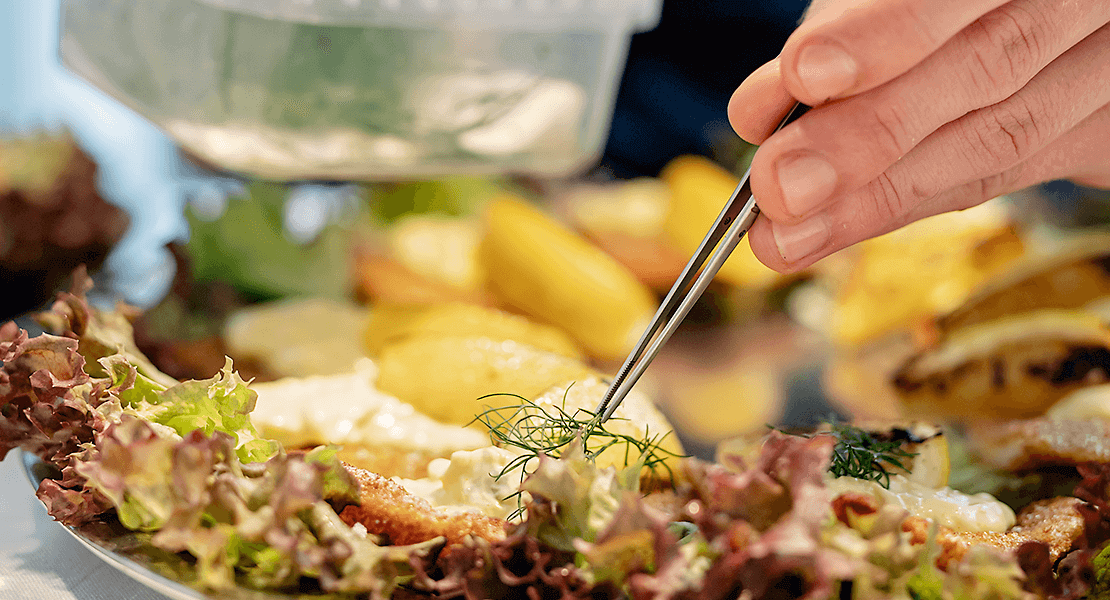 Adding an herb on top of a restaurant dish