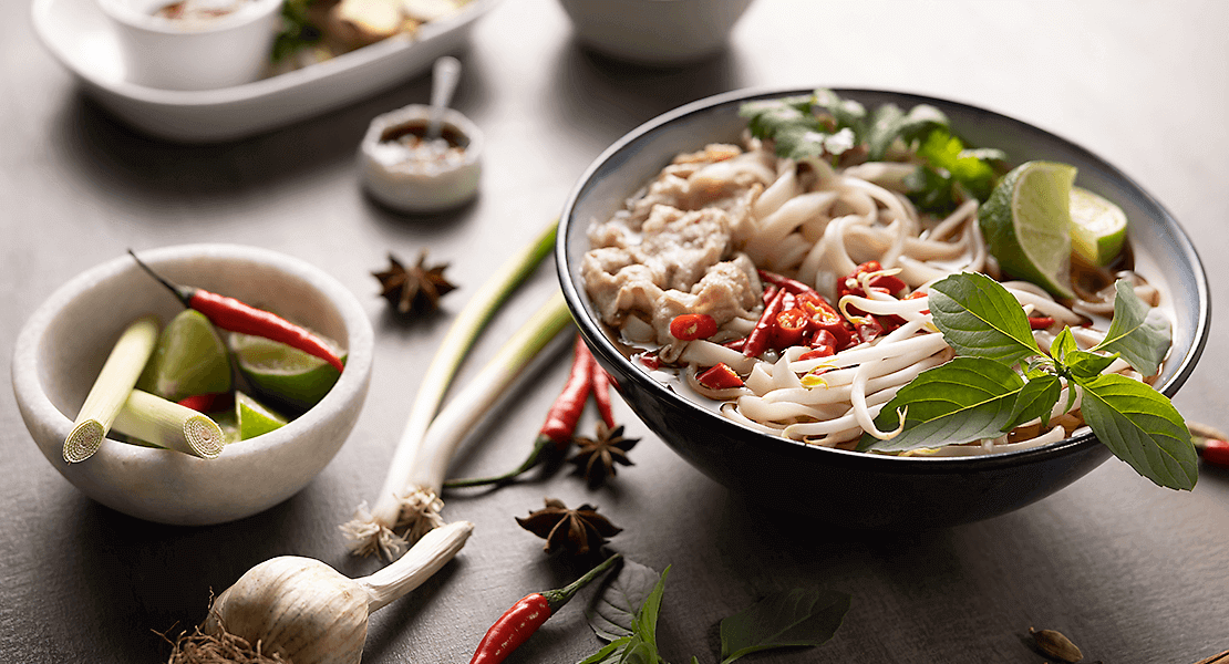 Asian noodle bowl with chili peppers, limes, and garlic