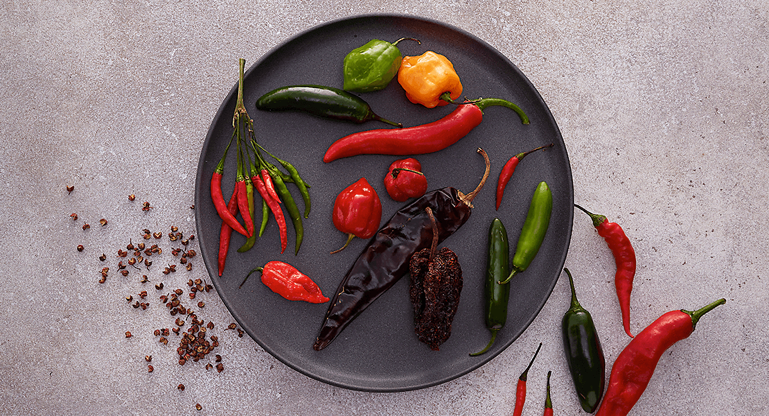 Various spicy peppers on a countertop