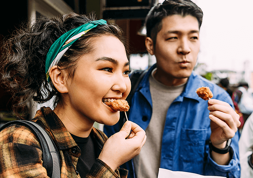 Two people sampling food