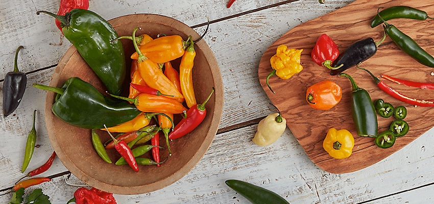 Bowl and cutting board with a variety of peppers