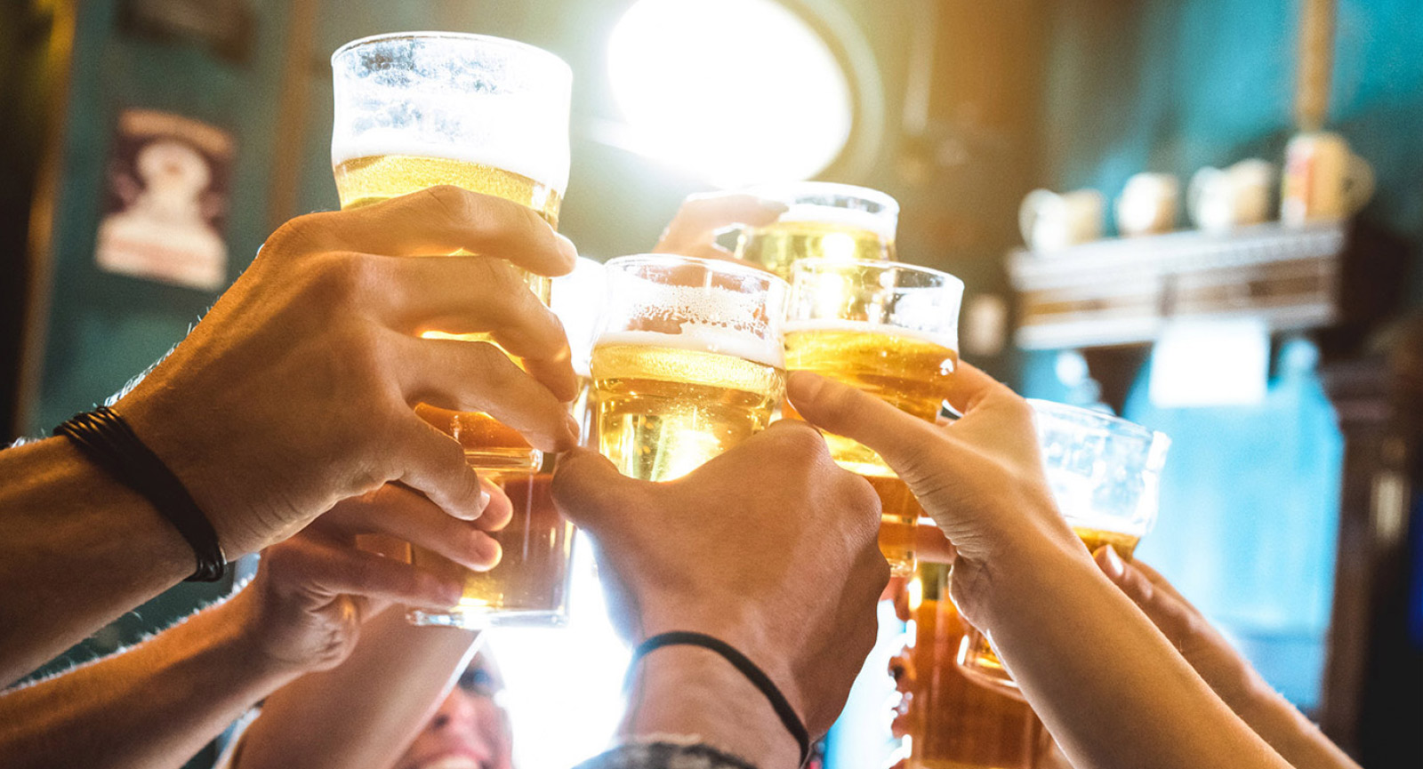 hands raising glasses of beer in a toast