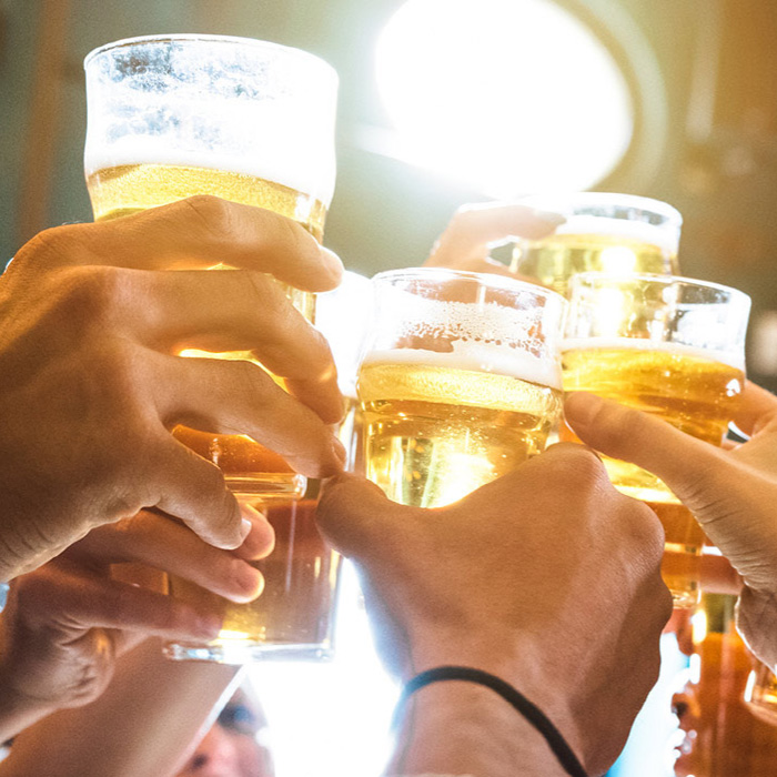 hands raising glasses of beer in a toast
